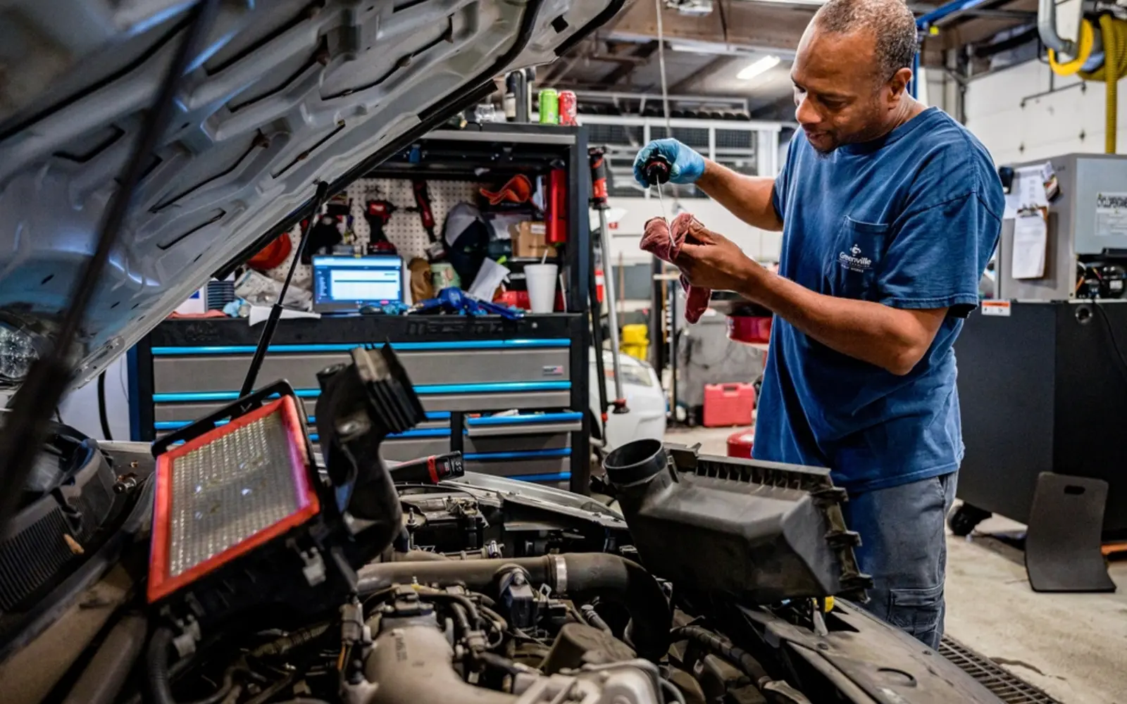 A mechanic working under the hood of a car